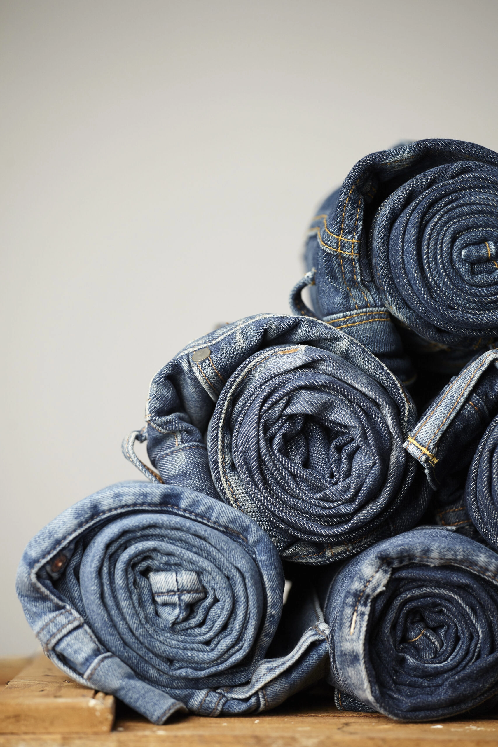 Jeans roulés et soigneusement pliés illustrant l’entretien des vêtements en denim