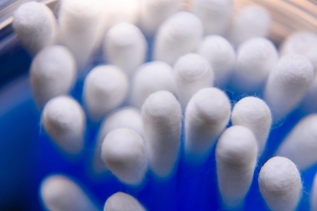 Coton-tige humide frotté sur un vêtement pour tester la tenue des couleurs