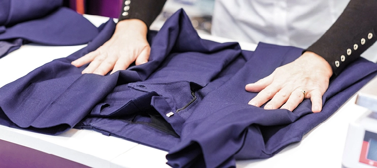 Employée 5àsec pliant la chemise d'un client