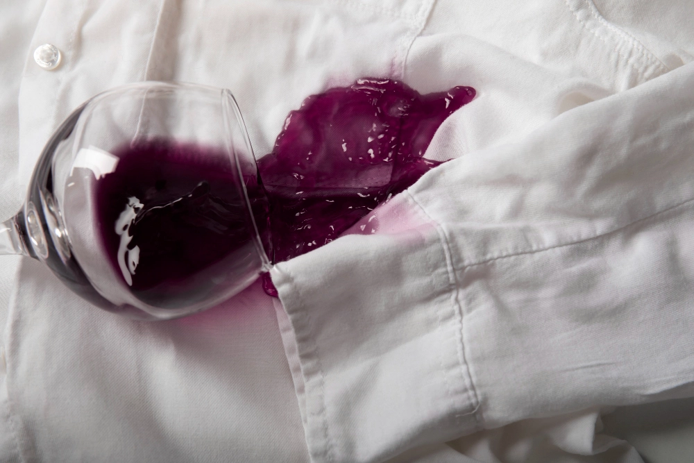 Tache de vin rouge sur chemise blanche nécessitant un traitement anti-taches vêtements professionnel
